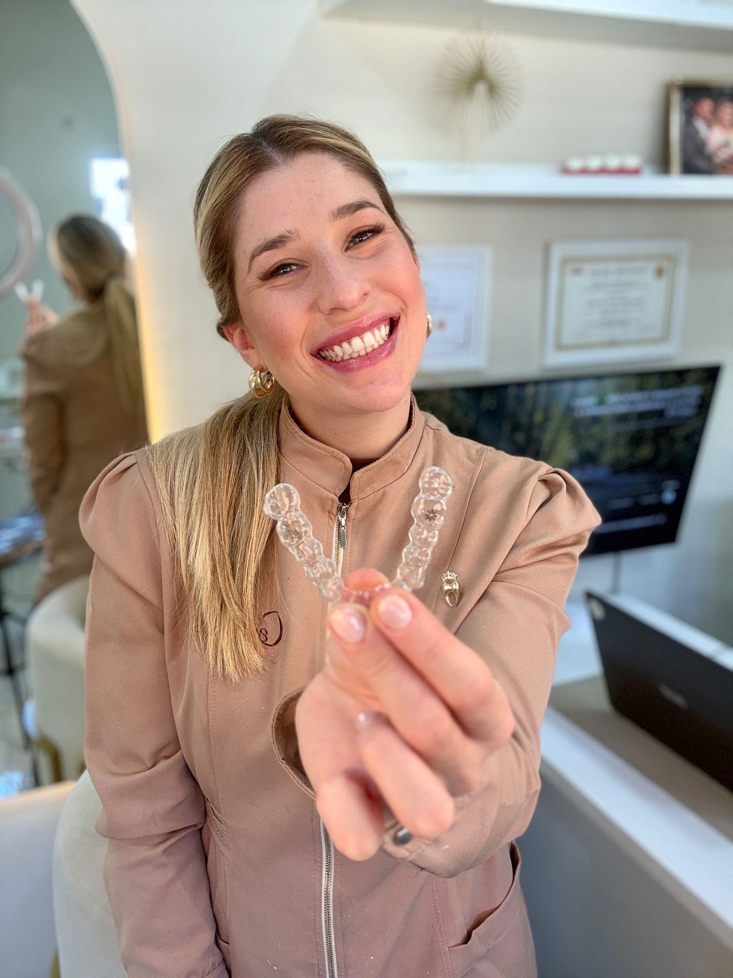 Dra. Carol Basile segurando alinhador transparente Invisalign